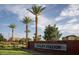 Welcome to Cooley Station, marked by a prominent brick sign and graceful palm trees against a bright, sunny sky at 4302 E Cynthia St, Gilbert, AZ 85295
