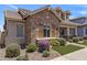 Home with stone accents, manicured landscaping, including colorful flowering bushes, and a well-kept lawn at 4302 E Cynthia St, Gilbert, AZ 85295