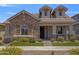 Inviting single-story home featuring a stone facade, covered porch, and professionally landscaped front yard at 4302 E Cynthia St, Gilbert, AZ 85295