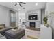 Comfortable living room boasts a fireplace, mounted television, and seamless open floorplan to dining area at 4302 E Cynthia St, Gilbert, AZ 85295
