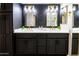 Stylish bathroom featuring dual sinks, gold fixtures, black cabinets, and elegant mirrors for a luxurious feel at 4303 E Cactus Rd # 128, Phoenix, AZ 85032