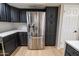 Updated kitchen with stainless steel refrigerator, white countertops, sleek black cabinetry, and tiled backsplash at 4303 E Cactus Rd # 128, Phoenix, AZ 85032