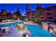 Resort-style pool featuring rock waterfalls and lush landscaping. The pool has seating and umbrellas at 4303 E Cactus Rd # 128, Phoenix, AZ 85032
