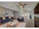 Spacious living room featuring vaulted ceilings, neutral paint, ceiling fans, and a cozy fireplace at 522 W Dennis Ct, Tempe, AZ 85283