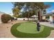 Manicured backyard with a putting green, large trees and mature landscaping perfect for relaxing outdoors at 5338 E Hearn Rd, Scottsdale, AZ 85254