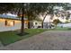 Spacious backyard with lush artificial turf, a putting green, outdoor dining area, and string lights for entertaining at 5338 E Hearn Rd, Scottsdale, AZ 85254