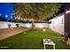 Large backyard featuring string lights, artificial turf, and cornhole boards, ideal for outdoor games and relaxation at 5338 E Hearn Rd, Scottsdale, AZ 85254