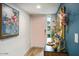 Charming foyer with pink door and buffet decorated with art at 5338 E Hearn Rd, Scottsdale, AZ 85254