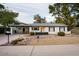 Charming single-story home featuring a landscaped front yard, white exterior, and welcoming pink front door at 5338 E Hearn Rd, Scottsdale, AZ 85254