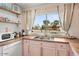 Well-lit kitchen with stainless steel sink, wood countertops, vintage pink cabinets, and ample storage at 5338 E Hearn Rd, Scottsdale, AZ 85254