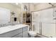 Bathroom with a glass enclosed shower, gray vanity, and decorative mirror at 5516 N 193Rd Ave, Litchfield Park, AZ 85340