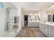Spacious bathroom with a glass-enclosed shower, dual vanities, and neutral tile flooring at 5516 N 193Rd Ave, Litchfield Park, AZ 85340