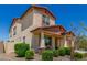 View of a two story home with stucco siding, a covered entrance and desert landscaping at 5516 N 193Rd Ave, Litchfield Park, AZ 85340
