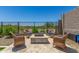 Backyard fire pit with stone pavers, surrounded by four wicker chairs with blue cushions at 5516 N 193Rd Ave, Litchfield Park, AZ 85340