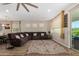 Living area with a large sectional sofa, wood-look floors, and large windows providing natural light at 5516 N 193Rd Ave, Litchfield Park, AZ 85340