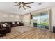 Spacious living room featuring wood floors, a ceiling fan, and a sliding door to the backyard at 5516 N 193Rd Ave, Litchfield Park, AZ 85340