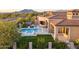 Scenic aerial view showcasing a pool with a spa, outdoor cooking area, mountain views, and beautiful landscaping at 7254 E Sonoran Trl, Scottsdale, AZ 85266