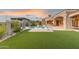 Lush backyard with artificial turf, pool, spa, and outdoor kitchen, ideal for relaxation and entertainment at 7254 E Sonoran Trl, Scottsdale, AZ 85266