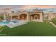 Expansive backyard with a pool, spa, outdoor kitchen, and lush artificial turf at 7254 E Sonoran Trl, Scottsdale, AZ 85266