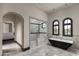 Luxurious bathroom featuring a walk-in shower, a soaking tub, and marble countertops at 7254 E Sonoran Trl, Scottsdale, AZ 85266