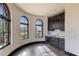 Sunlit bonus room with dark wood floors, a wet bar, and curved windows with scenic views at 7254 E Sonoran Trl, Scottsdale, AZ 85266