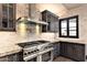 Modern kitchen with stainless steel appliances, a gas range, granite countertops and gray cabinetry at 7254 E Sonoran Trl, Scottsdale, AZ 85266
