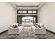Living room with plush seating, neutral colors, a fireplace and sliding glass doors to a covered outdoor living space at 7254 E Sonoran Trl, Scottsdale, AZ 85266