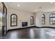 Bright living room featuring hardwood floors, a fireplace, and large arched windows with scenic views at 7254 E Sonoran Trl, Scottsdale, AZ 85266