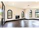 Bright living room featuring hardwood floors, a fireplace, and large arched windows with scenic views at 7254 E Sonoran Trl, Scottsdale, AZ 85266
