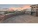 Expansive patio featuring an outdoor fireplace with picturesque desert views at sunset at 7254 E Sonoran Trl, Scottsdale, AZ 85266