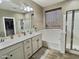 Bright bathroom with a double sink vanity, shower, tub, and wood-look floors at 7313 S 25Th S Dr, Phoenix, AZ 85041