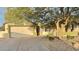 Charming home featuring a two-car garage, desert landscaping, and a mature tree at 7313 S 25Th S Dr, Phoenix, AZ 85041