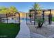 Fenced pool area with manicured landscaping, synthetic grass and stone pavers at 7313 S 25Th S Dr, Phoenix, AZ 85041
