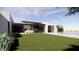 Lush backyard featuring green grass, outdoor kitchen, and a stylish modern home design at 8528 E Clydesdale Trl, Scottsdale, AZ 85258