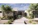 Contemporary home entrance with stone accents, metal gate, desert landscaping, and a stylish walkway at 8528 E Clydesdale Trl, Scottsdale, AZ 85258