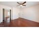 Bright bedroom with wood-look floors, ceiling fan, and mirrored closet at 874 E Lamonte St, San Tan Valley, AZ 85140