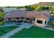 A desert home's backyard has well manicured turf and a cozy patio area for relaxing at 9183 W Shamel Ash Rd, Peoria, AZ 85383