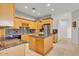 Spacious kitchen with wooden cabinets, island, stainless steel refrigerator, and granite countertops at 9183 W Shamel Ash Rd, Peoria, AZ 85383