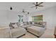Spacious living room featuring a large sectional sofa, tile floors, and two ceiling fans at 9183 W Shamel Ash Rd, Peoria, AZ 85383