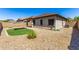 Low maintenance backyard with desert landscaping, artificial turf, covered patio, and brick perimeter wall at 923 E Randy St, Avondale, AZ 85323