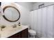 Well-lit bathroom featuring vanity with round mirror, tile floors, toilet, and shower with curtain at 923 E Randy St, Avondale, AZ 85323