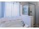 Bathroom showcasing a soaking tub with brushed nickel fixtures and seamless glass shower enclosure at 923 E Randy St, Avondale, AZ 85323