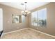 Bright dining area features tile floors, neutral paint, large window, and chandelier at 9465 W Tonopah Dr, Peoria, AZ 85382
