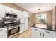 Kitchen featuring white cabinets, stainless steel appliances, mosaic tile backsplash, and dining nook at 9465 W Tonopah Dr, Peoria, AZ 85382