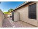 A side yard with gravel, stepping stones, and a neutral shed along a tan stucco exterior, providing practical outdoor storage at 9465 W Tonopah Dr, Peoria, AZ 85382
