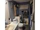 Compact bathroom featuring essential amenities, including a toilet, sink, and storage shelves at 303 S Recker Rd # 98, Mesa, AZ 85206