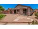 The spacious backyard features desert landscaping, a covered patio, and a brick border at 105 W Monona Dr, Phoenix, AZ 85027