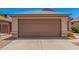 Attached single car garage featuring a brown door and concrete driveway at 105 W Monona Dr, Phoenix, AZ 85027