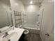 Bright bathroom showcasing a shower-tub combo with white tile surround and a modern vanity with shelving at 13142 E Aster Ln, Florence, AZ 85132
