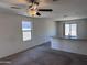 Bright open-concept living room featuring plush carpeting and a kitchen counter with granite countertops at 13142 E Aster Ln, Florence, AZ 85132